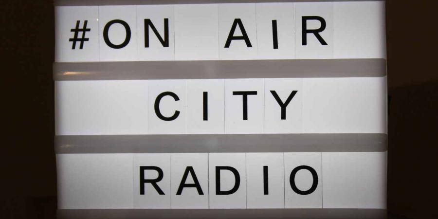 Leuchttafel mit dem Schriftzug # on air City Radio