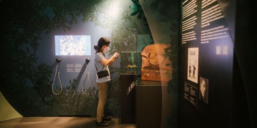 Eine Frau macht ein Foto von einem Objekt in der Ausstellung BERLIN GLOBAL