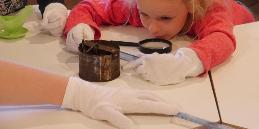 Ein Kind untersucht ein Museumsobjekt 