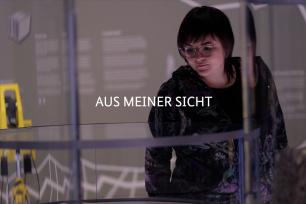 Eine Frau in der Ausstellung Berlin Global, die auf eine Vitrine schaut