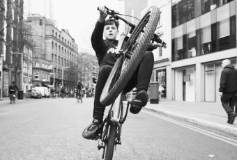 Junge auf Fahrrad macht Wheelie während der Bikestormz in London