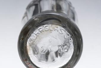 Detailansicht der Coca-Cola-Flasche mit Herstellerprägung „Ruhrglas 37“ © Stadtmuseum Berlin | Foto: Oliver Ziebe