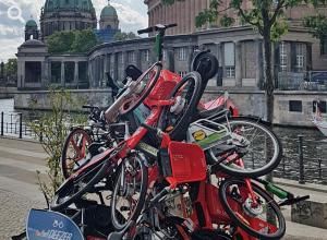 Ein Haufen übereinandergeworfener Bikesharing-Fahrräder am Landwehrkanal nahe dem Dom