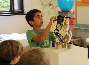 Kind mit selbst gebautem Roboter 