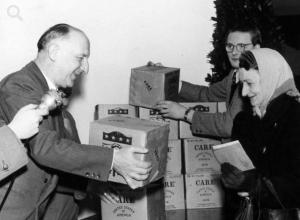 West-Berlins damaliger Regierender Bürgermeister Dr. Otto Suhr übergibt ein Care-Paket an eine Rentnerin, Dezember 1954