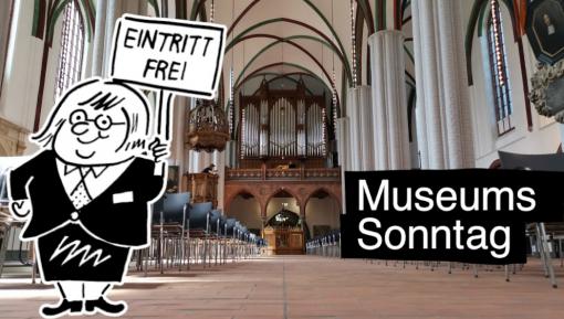 Cartoon-Figur mit einem Schild mit der Aufschrift "Eintritt frei" im Museum Nikolaikirche