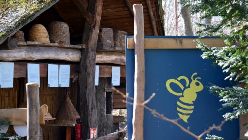 Bienenkörbe in einem Haus und eine Informationstafel