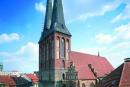 Die Nikolaikirche mit ihrem Turmsockel aus grauen Feldsteinen und den Zwillingstürmen aus rotem Backstein mit grünen Turmspitzen.