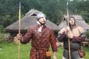 Darsteller in mittelalterlicher Kleidung vor historischer Kulisse im Museumsdorf Düppel